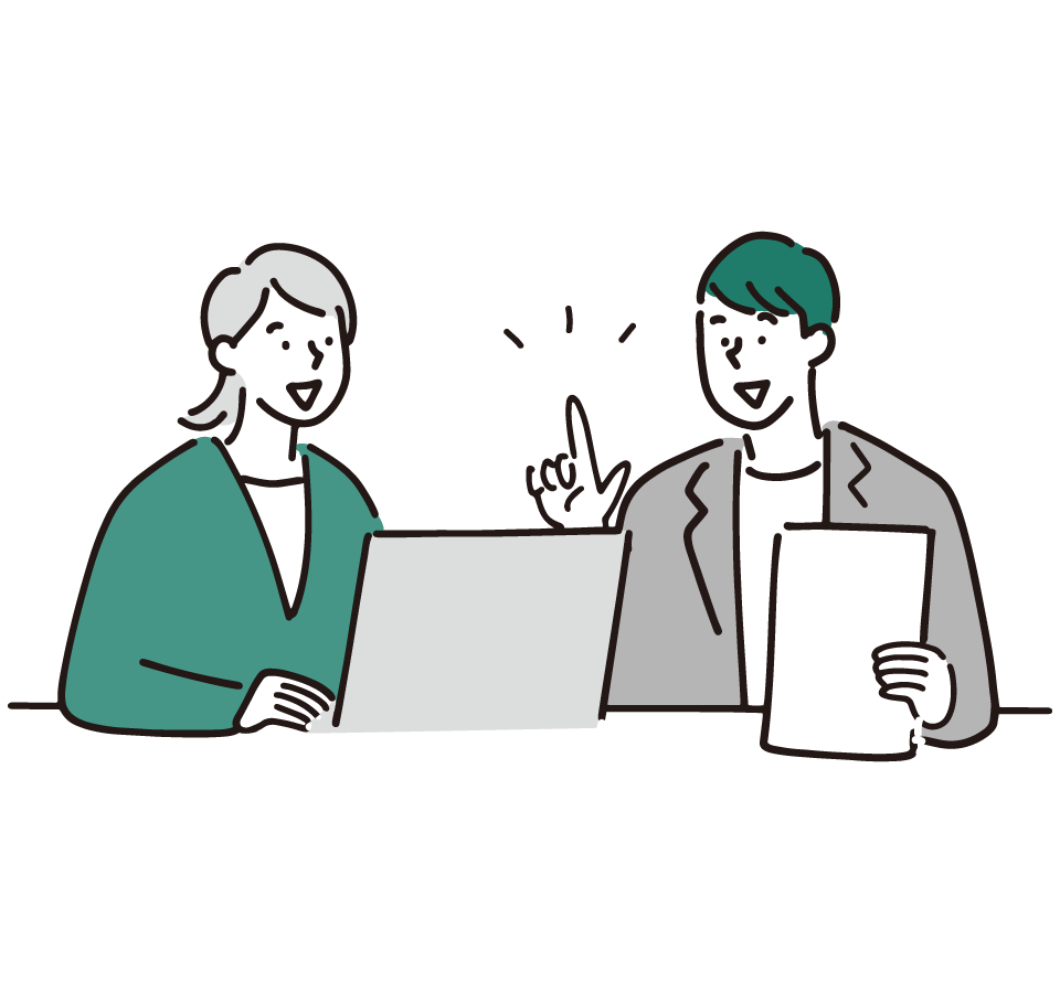 Two coworkers collaborate at a desk with a laptop and a stack of papers. (informative)